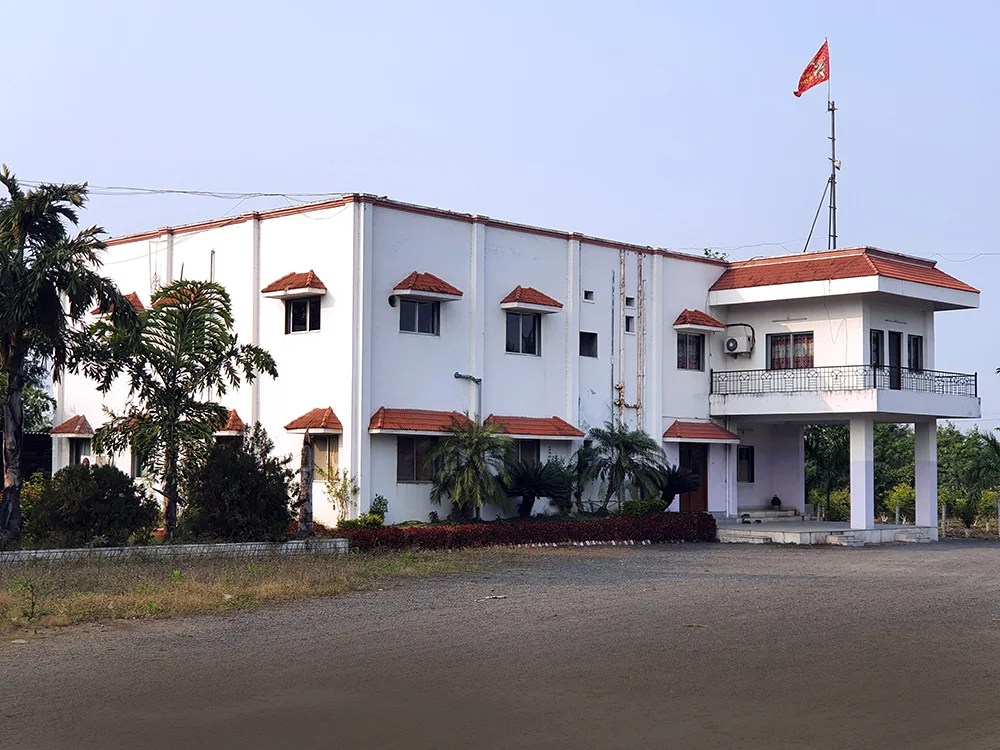 Exterior of a mill facility surrounded by greenery