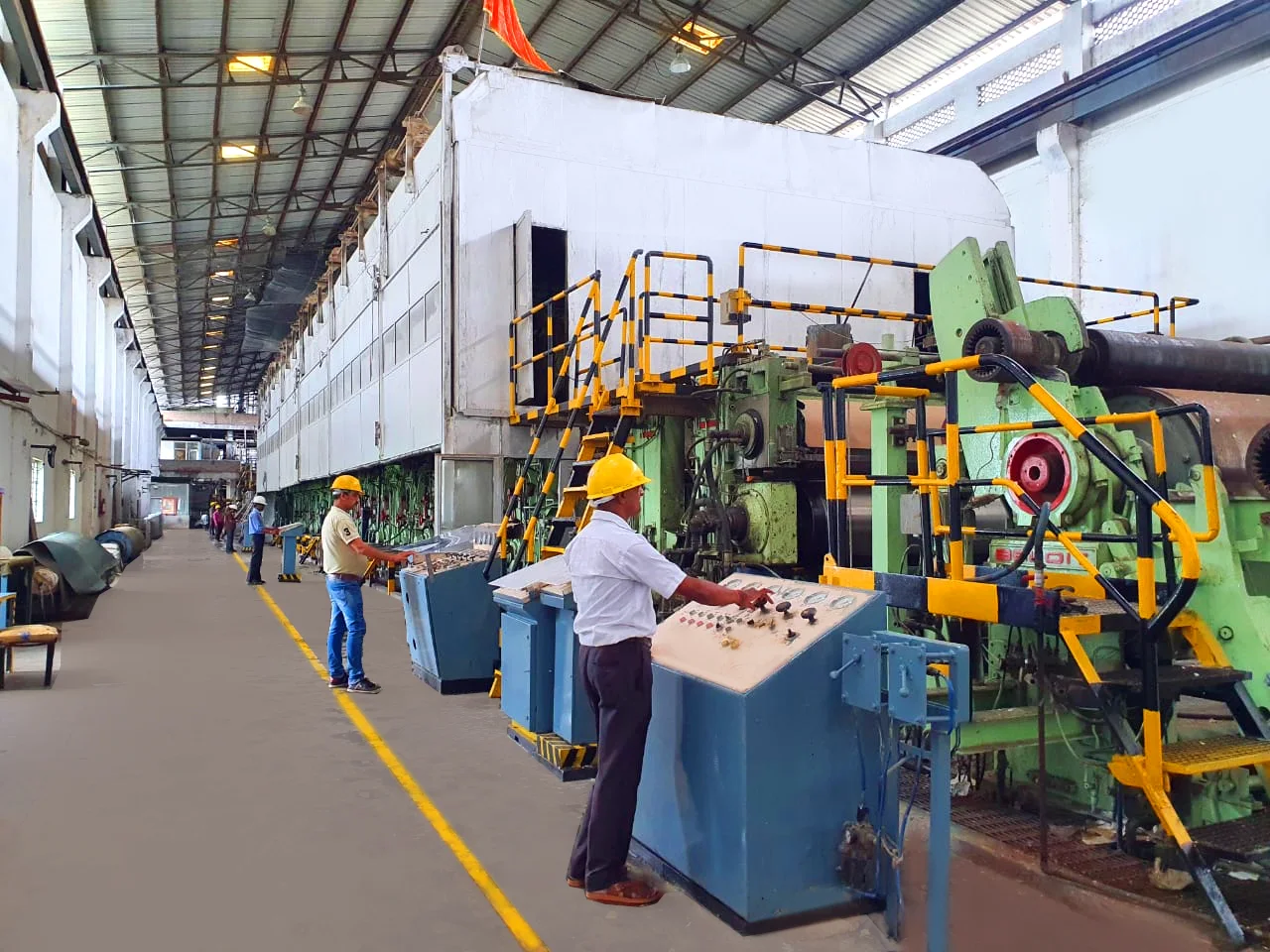 Operators beside paper-making machinery and control consoles